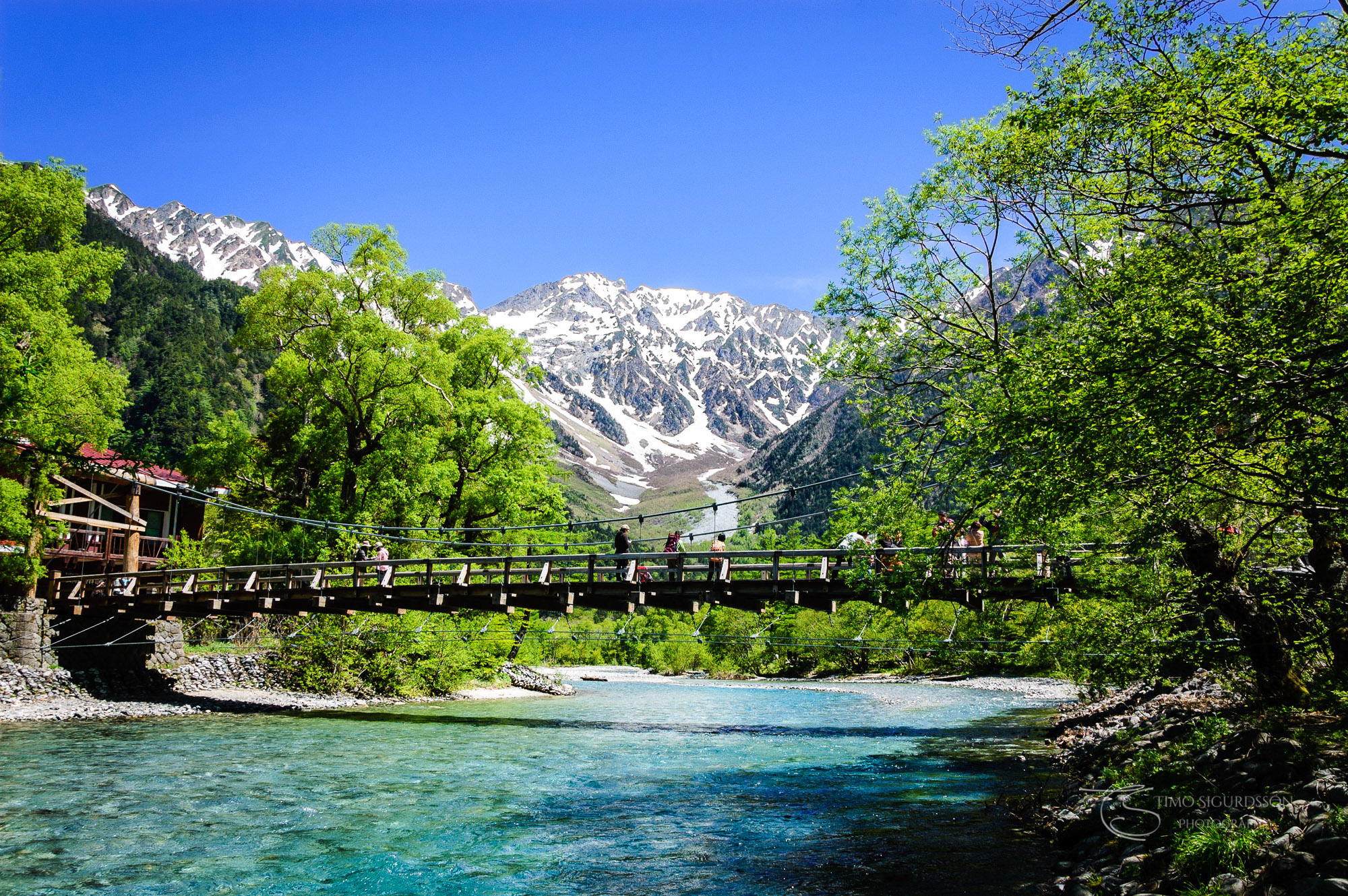 Kamikochi National Park, Japan. Bridge over Azusa river. Mountain and snow.