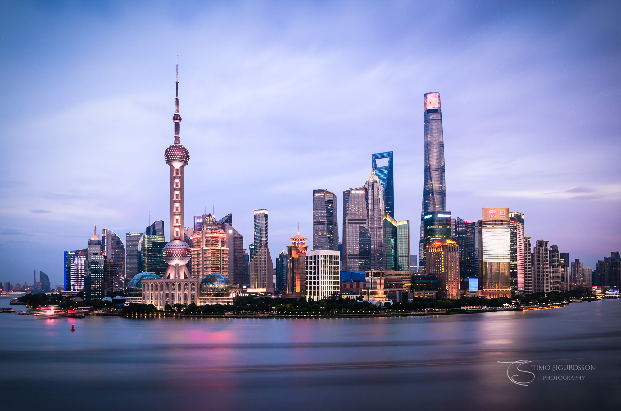 Shanghai, China. Pudong skyline at dusk. Huangpu river.